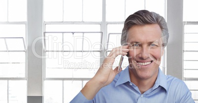 Happy business man talking on the phone against building background