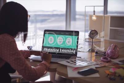 Woman using a computer Person holding a phone with e-learning information in the screen