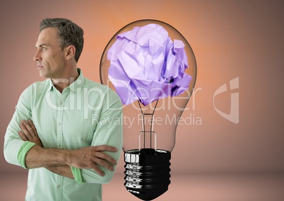 Man standing next to light bulb with crumpled paper ball