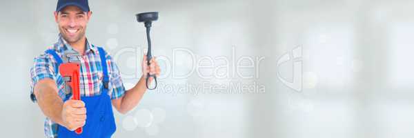 Happy plumber man holding a plunger and a wrench against white background with flares