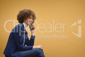 Happy business woman talking on the phone against orange background