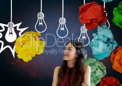Woman standing next to light bulbs with crumpled paper balls