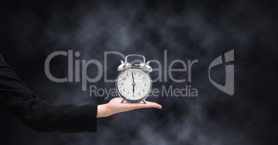 Arm holding clock in front of dark background