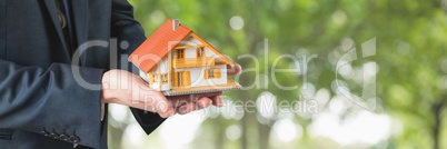 Man holding a house as house insurance concept