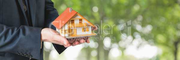 Man holding a house as house insurance concept
