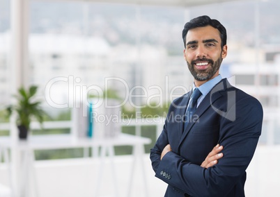 Happy business man standing against office background