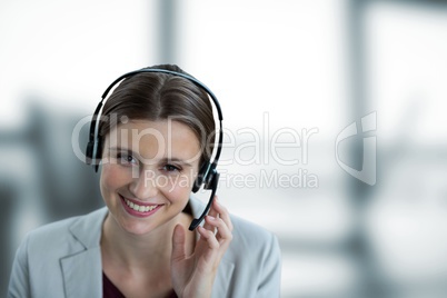 Happy business woman with earphones against blue and white blurred background