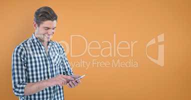 Happy man using a phone against orange background