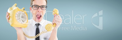 Angry man holding a yellow phone against blue background