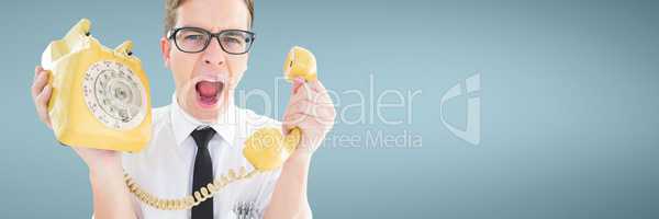 Angry man holding a yellow phone against blue background