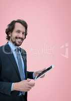 Happy business man using a tablet against pink background