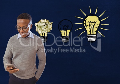 Man on phone standing next to light bulbs with crumpled paper ball in front of blackboard