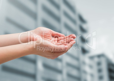 Hands cupped in front of buildings