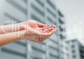 Hands cupped in front of buildings