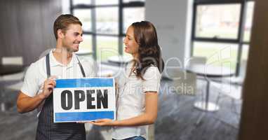 Happy small business owners holding an open sign