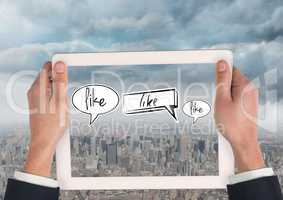 Holding tablet and Like speech bubbles over city