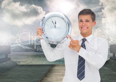 man holding clock in front of landscape