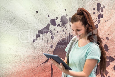 Happy young student woman holding a tablet against white, red and purple splattered background