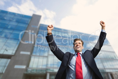 Excited business man standing against building background