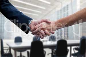 Business people shaking hands against office background