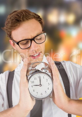 man holding clock in front of blurred colorful background