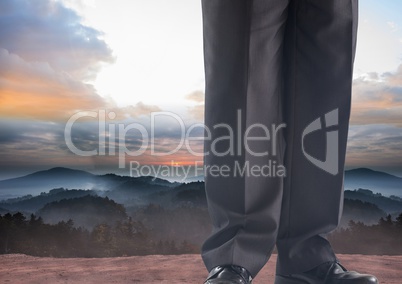 Businessman's legs in front of landscape