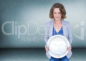 Woman holding clock in front of room