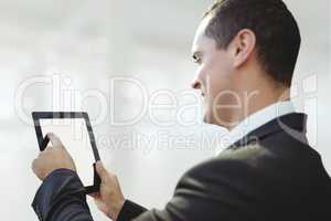 Happy business man using a tablet against white blurred background