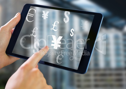 Holding tablet and Mixed Currency icons over city