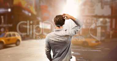 Confused business man standing against city background