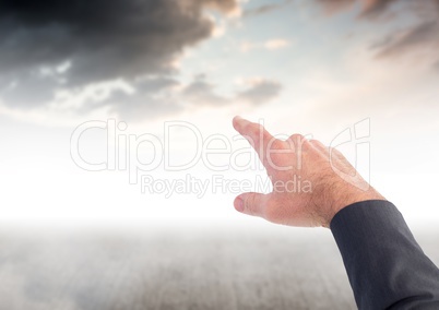 Hand pointing at dark clouds