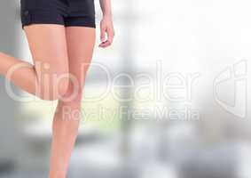 Slim athletic woman's legs in front of windows