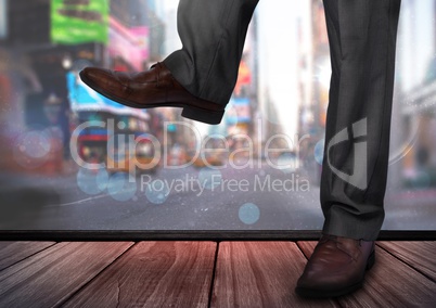 Mans legs and feet in front of city