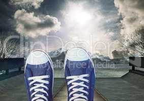 Shoes relaxing feet in front of dramataic sky clouds and mountain trees