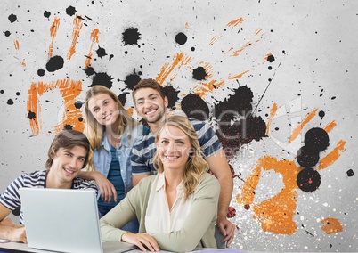 Happy young students using a computer against grey, yellow and black splattered background