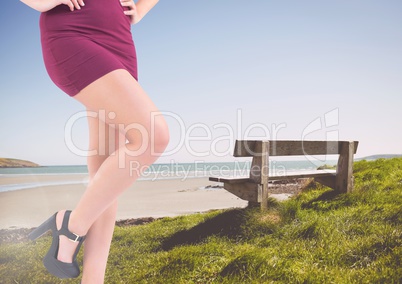 Sexy woman's legs by a bench at the sea