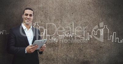 Happy business man holding a tablet against grey wall background with city icons