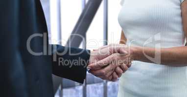 Business people shaking hands against city background