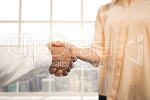 Business people shaking hands against city background