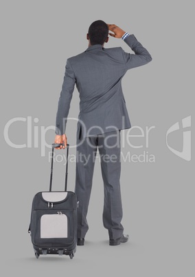 Full body portrait of man holding suitcase standing with grey background