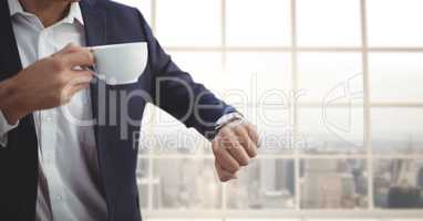 Business man holding a cup of coffee against building background