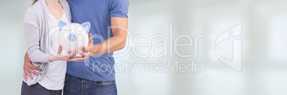 Couple holding a piggy bank against white background with flares