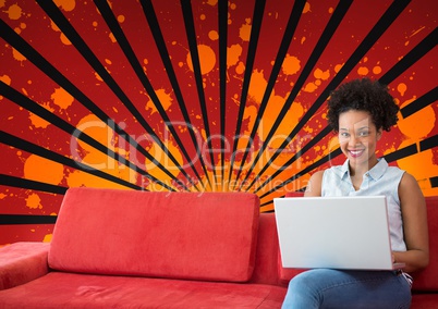 Happy young student woman using a computer against red, black and orange splattered background