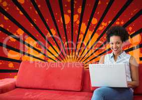 Happy young student woman using a computer against red, black and orange splattered background