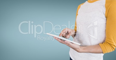 Business man using a tablet against blue background