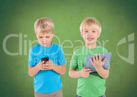 Blonde boys with tablet and phone in front of green background