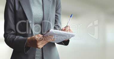 Business woman writing against white blurred background