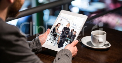 Cropped image of businessman attending conference call on tablet PC in cafe