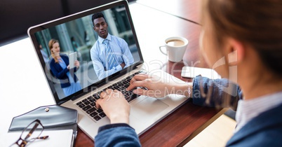 High angle view of businesswoman video conferencing on laptop at desk