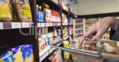 Hand taking picture of products with digital tablet at departmental store